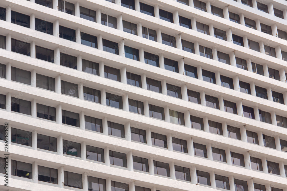 Glass windows and concrete walls in the daytime. Arcitectural fragment of modern building in Bangkok, Thailand.