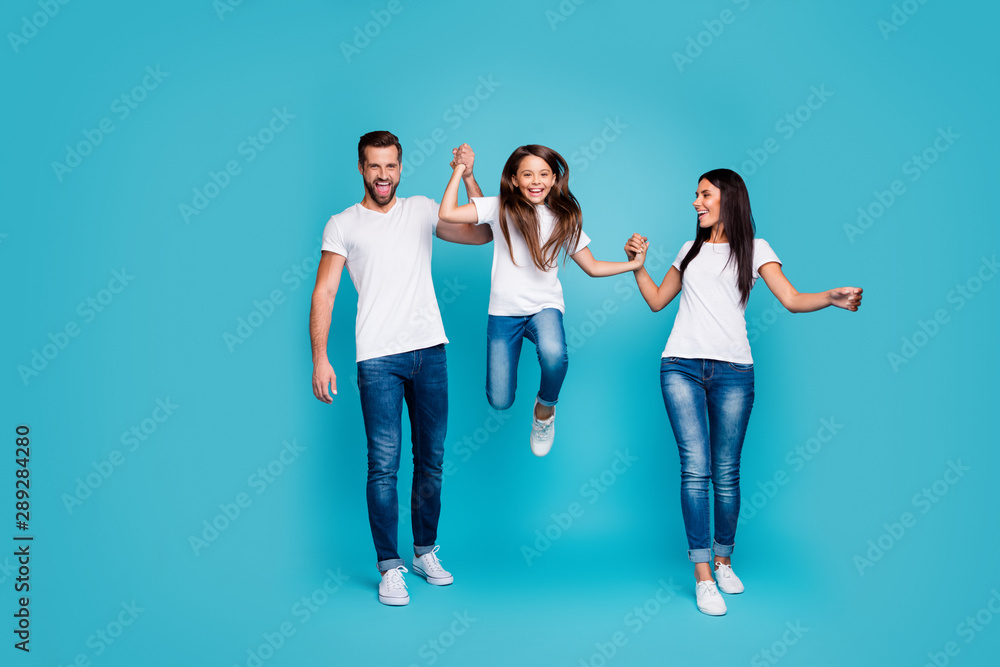 Full size photo of daddy mommy and small lady going and jumping together wear casual outfit isolated blue background