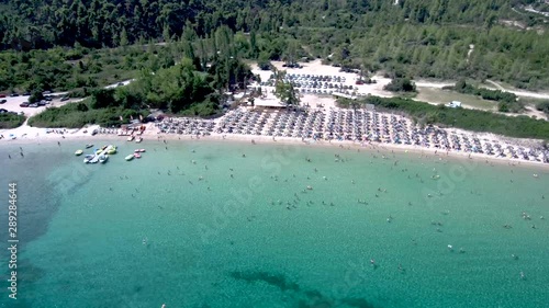 Aerial view of long idyllic turquoise water beach at  Pefkohori Halkidiki, Greece, circular movement by drone photo