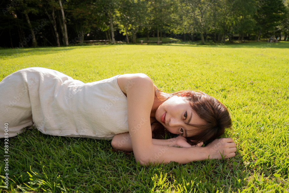 芝生に寝転ぶ女性