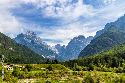 Panoramic view on Mangart-Jalovec Mountain Massive in the Julian Alps inside beautiful Landscape. Log pod Mangartom, Bovec, Slovenia, Europe. © unununius