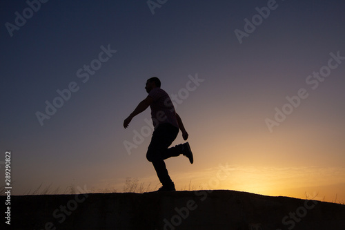 Fototapeta Naklejka Na Ścianę i Meble -  silhouette of man running at sunrise