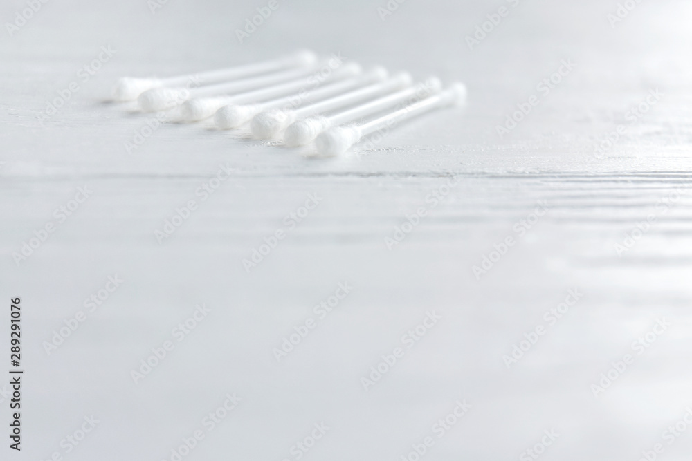 Soft focus. Group of clean white cotton swabs for personal hygiene with selective focus on blurred neutral background. Cosmetic cotton buds for healthcare. Soft cotton sticks for earwax. Cotton swab Soft focus. Group of clean white cotton swabs for personal hygiene with selective focus on blurred neutral background. Cosmetic cotton buds for healthcare. Soft cotton sticks for earwax. Cotton swab
