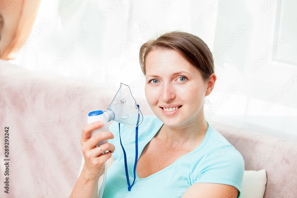 Young woman doing inhalation with a nebulizer at home Young woman doing inhalation with a nebulizer at home