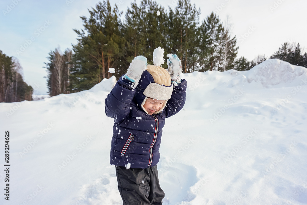 portrait of a happy child boy throws snow, snowflakes in the air in cold winter against the background of snowdrifts portrait of a happy child boy throws snow, snowflakes in the air in cold winter against the background of snowdrifts
