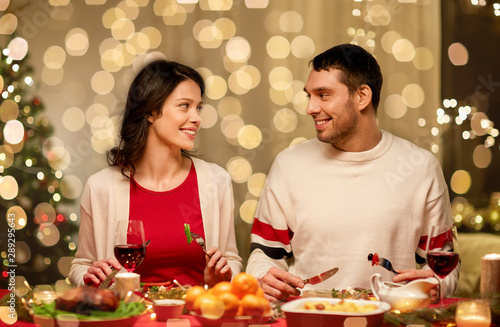 holidays  eating and celebration concept - happy couple having christmas dinner at home