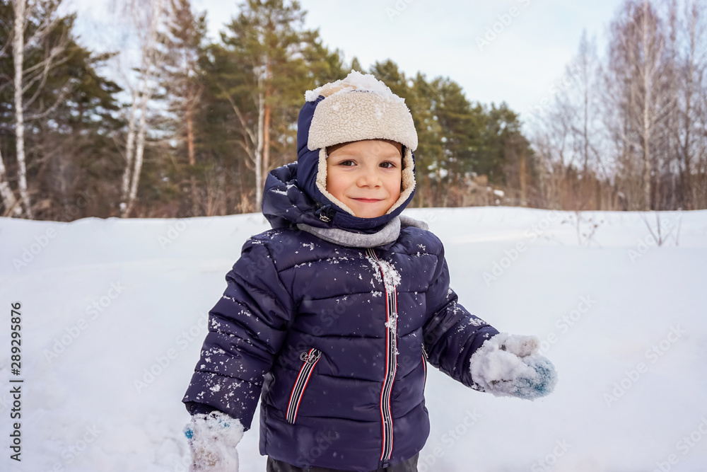 portrait of a happy child boy throws snow, snowflakes in the air in cold winter against the background of snowdrifts portrait of a happy child boy throws snow, snowflakes in the air in cold winter against the background of snowdrifts