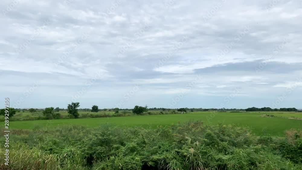 Open Green Grassy Farm Fields On A Cloudy Day. TRUCK LEFT Open Green Grassy Farm Fields On A Cloudy Day. TRUCK LEFT
