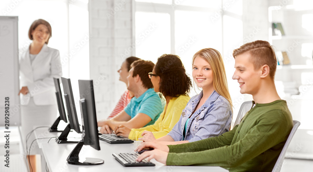 Obraz premium education, technology and learning concept - group of happy international high school students or classmates in computer class