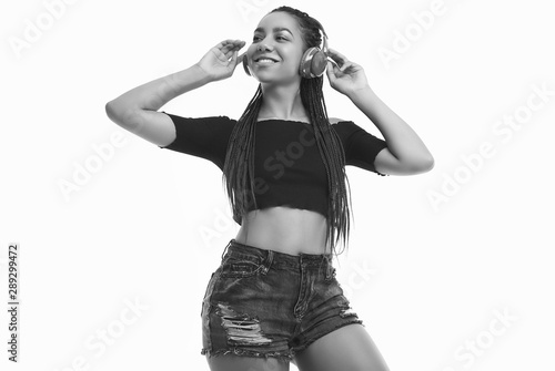 Beautiful african brunette teenage girl with dreadlocks listening music