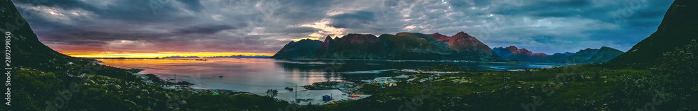 Panoramic photo of Norway with sea, hill with cloudy sky on summer at sunset