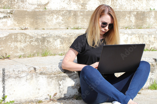 Beauty using a modern netbook writes an article outside the workplace. Free work schedule for an IT specialist. © loran4a