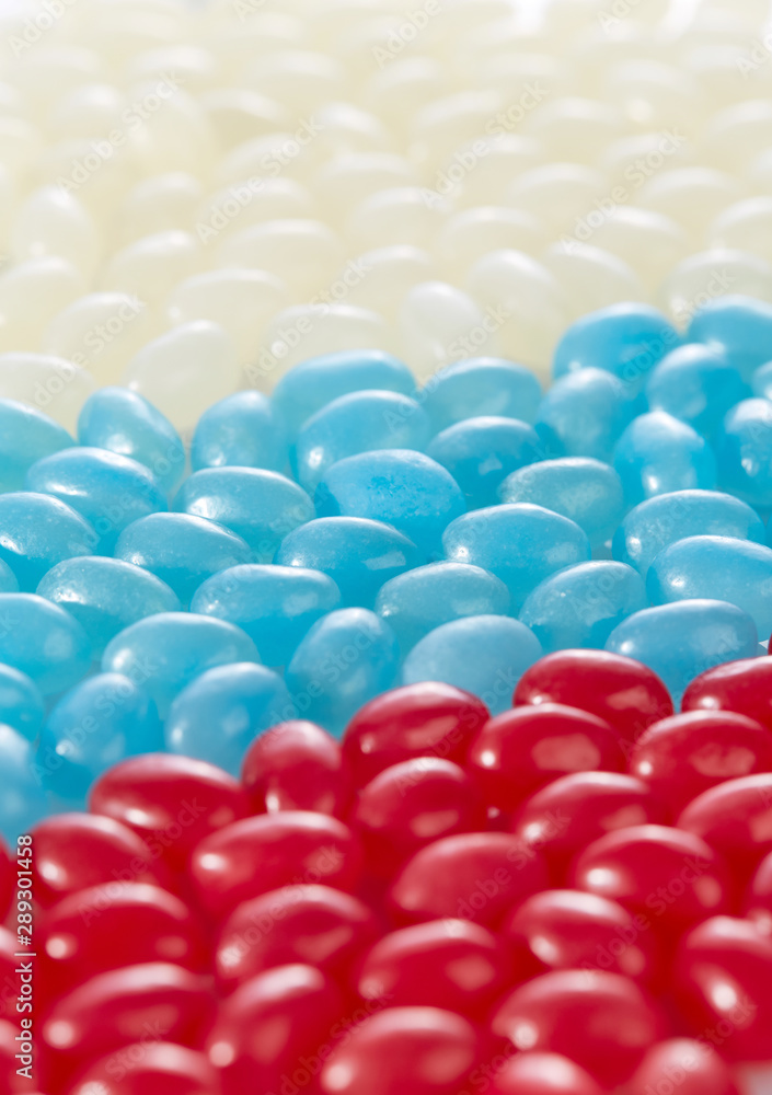 Assorted caramels of different flavors are arranged in the colors of the Russian flag. Concept: sweet life in Russia. Vertical image. Assorted caramels of different flavors are arranged in the colors of the Russian flag. Concept: sweet life in Russia. Vertical image.