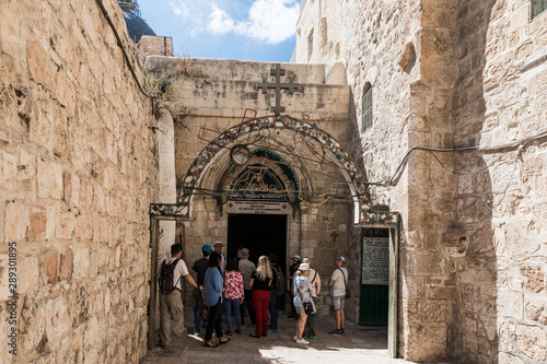 Tourists listen to a licensed guide near the entrance to the Coptic Orthodox Patriarchate in the Old City in Jerusalem, Israel © svarshik
