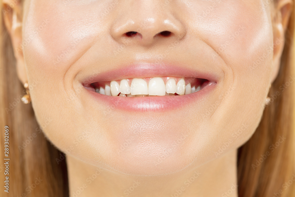 Obraz premium Close up shot of young woman on yellow studio background. Beautiful female model with well-kept skin. Concept of human emotions, facial expression, beauty, healthy lifestyle. Lips, teeth smiling.