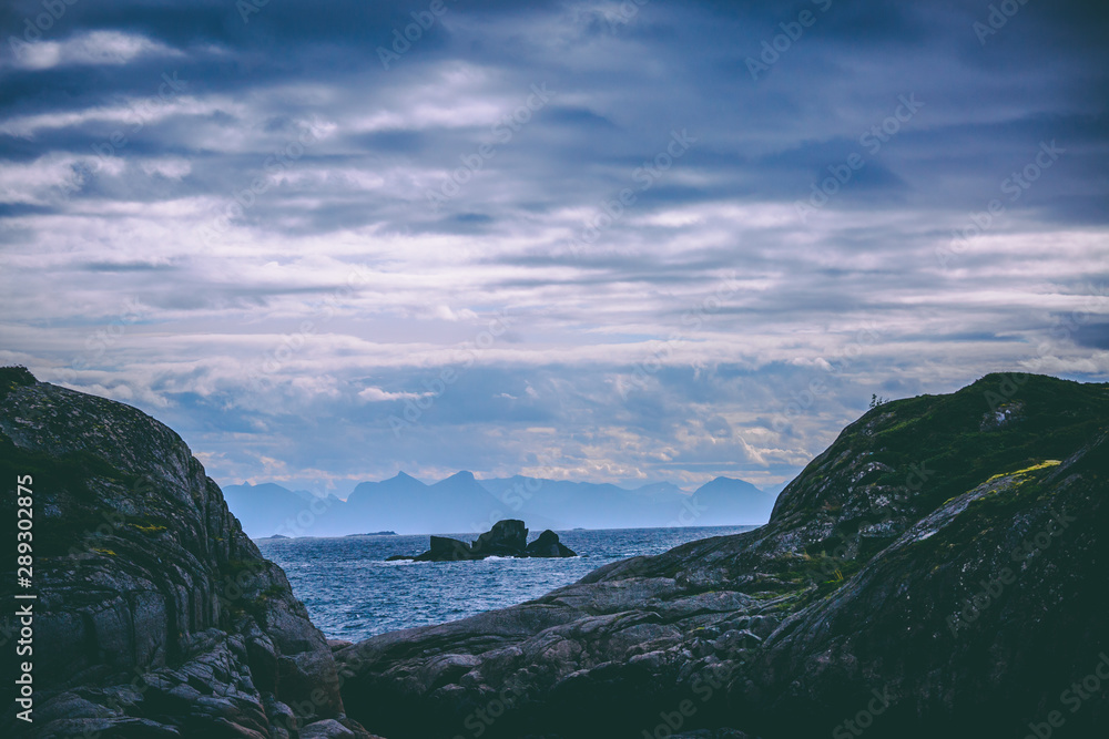 Photo of Norway with sea, hill with cloudy sky on summer at sunset