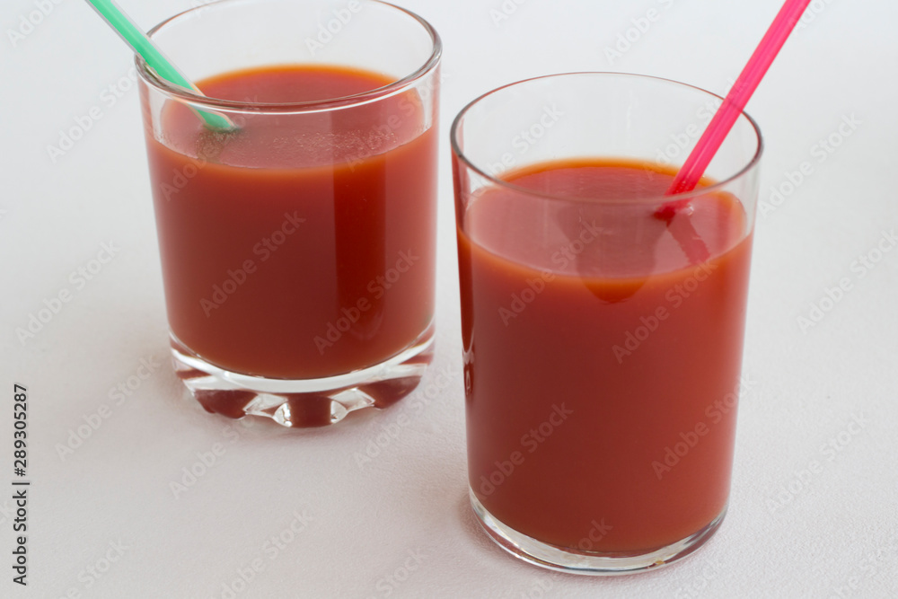 Two glasses of tomato juice on a white background Two glasses of tomato juice on a white background