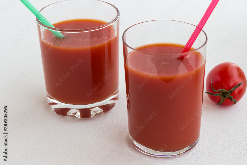 Two glasses of tomato juice on a white background Two glasses of tomato juice on a white background