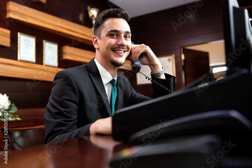 Elegantly dressed receptionist holding a headphone photo