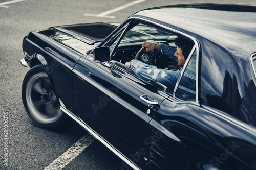 A man driving old black stylish car