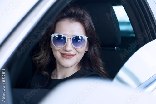 young woman traveller taking photos from car window