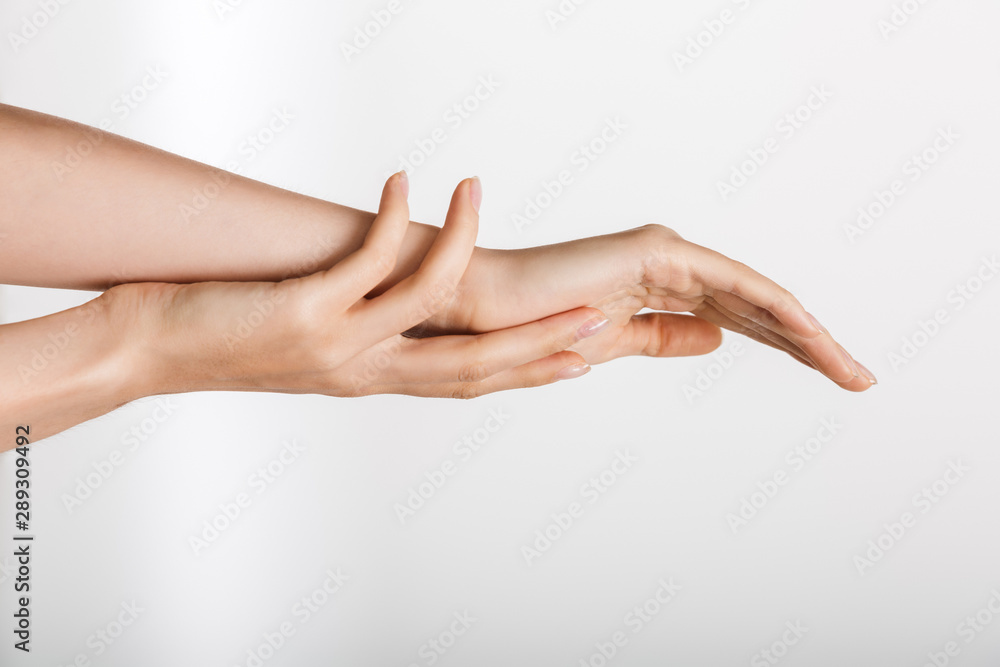 Woman's hands isolated over white wall background touching each other.