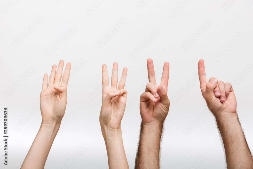 Man's and woman's hands isolated over white wall background showing counting numbers by fingers. Man's and woman's hands isolated over white wall background showing counting numbers by fingers.
