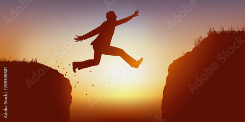 Concept de l’ambition avec un homme audacieux qui saute dans le vide pour passer un obstacle et atteindre son objectif.