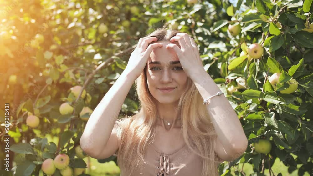 Beautiful seventeen year old girl blonde posing in the branches of an apple tree Beautiful seventeen year old girl blonde posing in the branches of an apple tree
