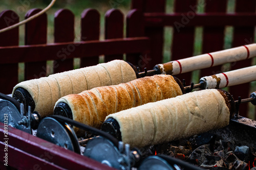 Preparation of the famous, traditional and delicious Hungarian Chimney Cake Kurtos Kolacs (Kürtőskalács) photo