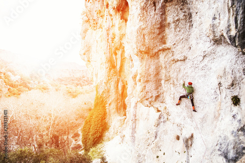 Climber overcomes challenging climbing route. A girl climbs a rock. Woman engaged in extreme sport. Extreme hobby.