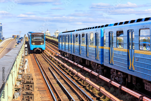 Two metro trains go towards each other along the metro bridge in Kyiv across the Dnipro River.