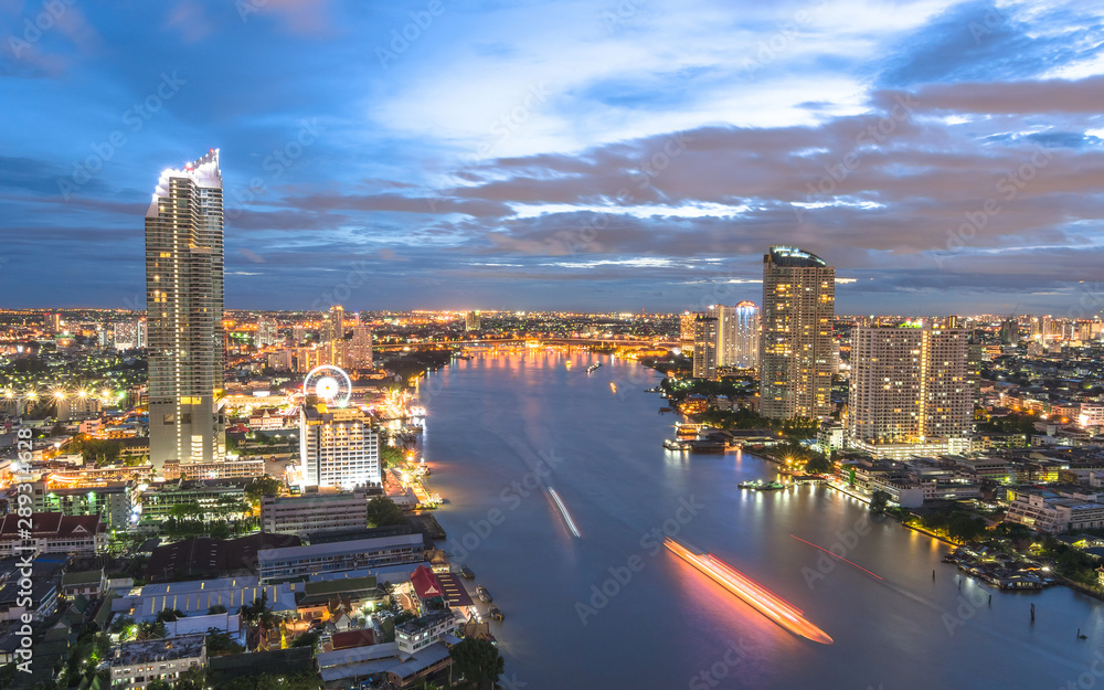 Obraz premium Bangkok cityscape rooftop view at night over Chao Phraya River waterfront with hotel buildings in central business district (CBD) and tourist boats transportation
