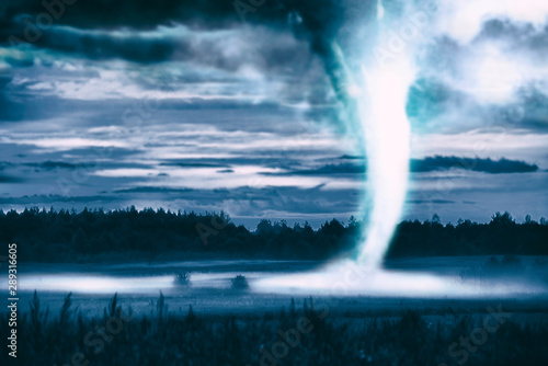 Tornado forming at night from a supercell storm through the fields.