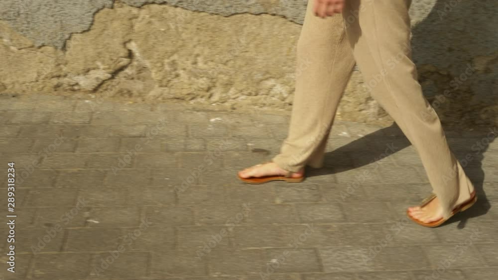 Womans Legs with Flowy Pants Walking on Concrete Pavement in Summer Womans Legs with Flowy Pants Walking on Concrete Pavement in Summer