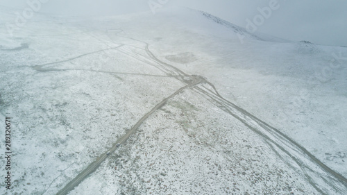 top view of a car driving along a winding mountain road through the winter desert in Mongolia © Jonny
