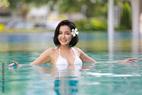 Portrait Of Smiling Young Woman bikini Standing In Swimming Pool