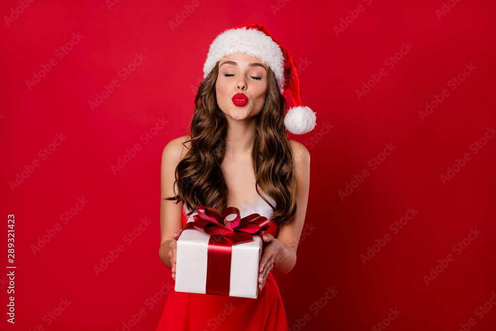 Pretty lady holding big giftbox in hands sending air kiss to handsome santa wear fluffy mini dress isolated red background Pretty lady holding big giftbox in hands sending air kiss to handsome santa wear fluffy mini dress isolated red background