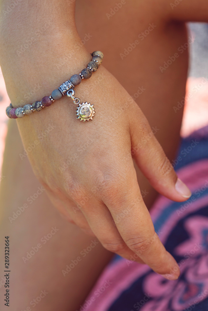 Female hand wearing mineral stone beads yoga bracelet