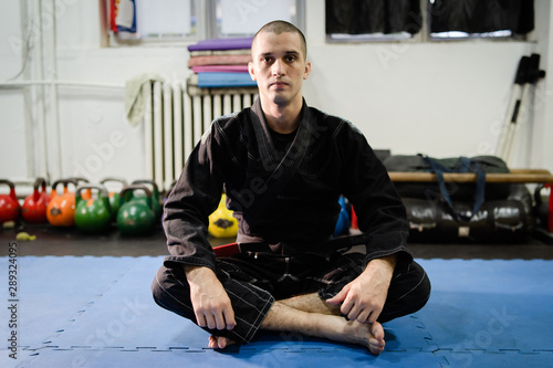 Tableau sur toile Young bjj brazilian jiu jitsu athlete jujitsu fighter sitting on the tatami mats