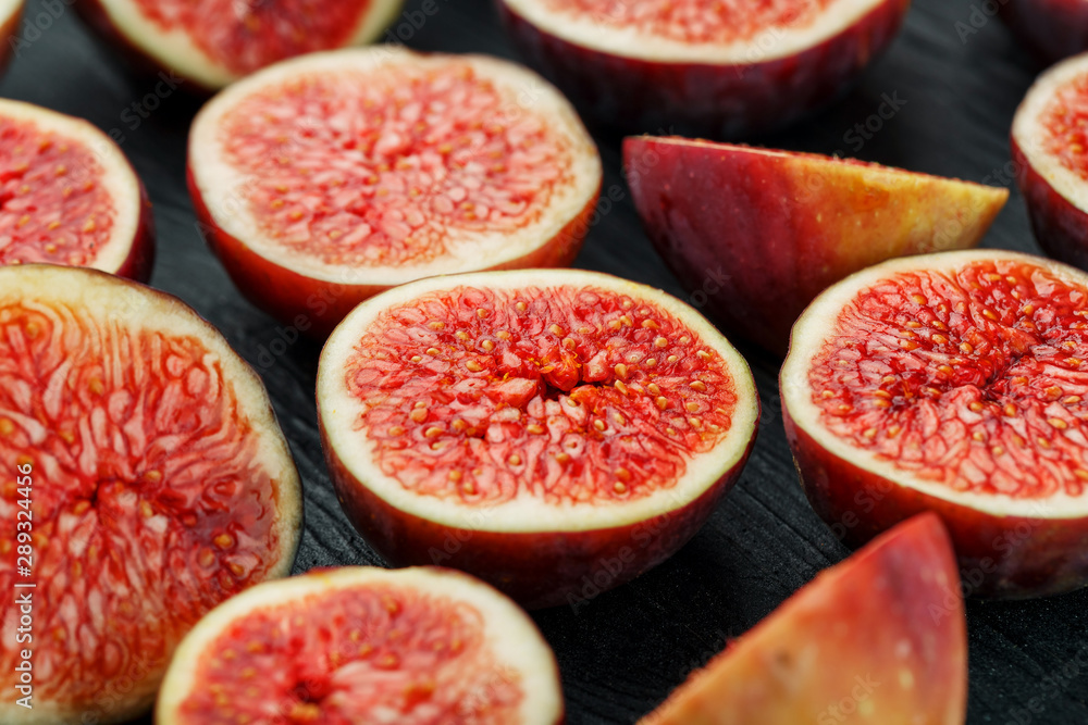 Ripe Figs. Creative diagram of chopped figs on a black textural background in the form of a texture inscribed in a rectangle Ripe Figs. Creative diagram of chopped figs on a black textural background in the form of a texture inscribed in a rectangle