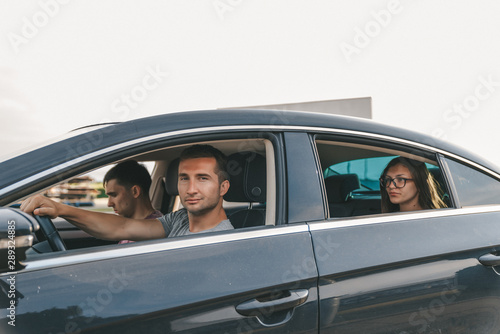Young friends in casual clothes traveling together by the car © Vasya