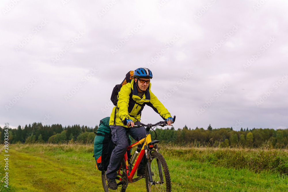 bikepacker rides on a dirt road through a field bikepacker rides on a dirt road through a field