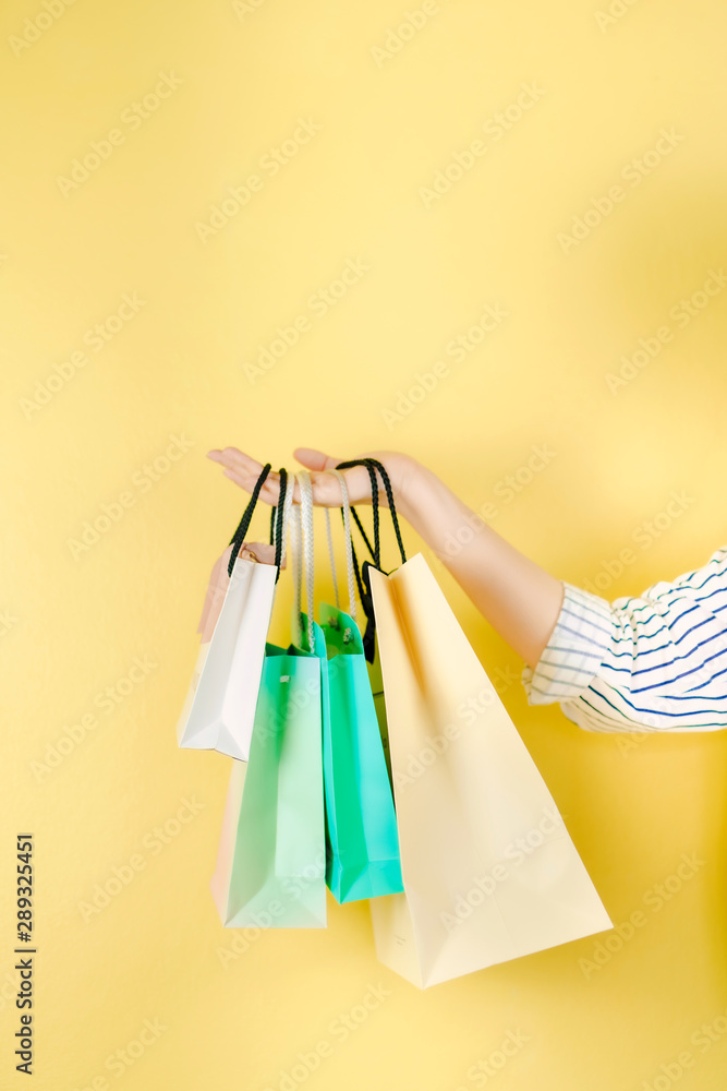 mid season sale and shopping activity from hand hold the shopping bag with copy space and yellow vintage background