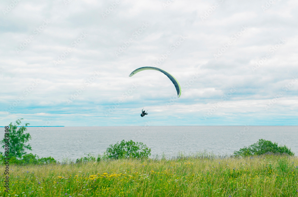 one paraglider in the sky over the open sea on a background of blue sky and white clouds on a cloudy day. extreme sport. landscape. one paraglider in the sky over the open sea on a background of blue sky and white clouds on a cloudy day. extreme sport. landscape.