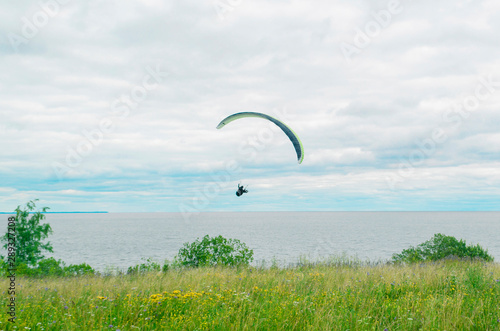 one paraglider in the sky over the open sea on a background of blue sky and white clouds on a cloudy day. extreme sport. landscape.