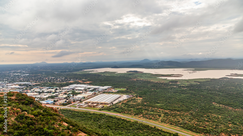 Aerial view of suburbs of Gaborone city spread out over the savannah and lake in the background, Gaborone, Botswana, Africa