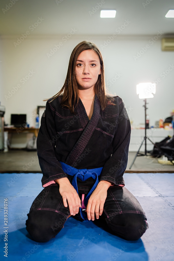 Young bjj brazilian jiu jitsu girl female woman athlete jujitsu fighter sitting on the tatami