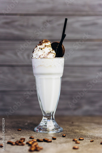 Delicious cold milkshake with cocoa and chocolate in a glass.