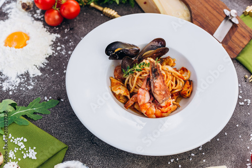 Pasta with king prawns on a gray background in a white dish.